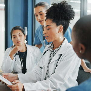 Doctors, nurse and women on clipboard in meeting, collaboration or teamwork for hospital planning, medical or life insurance. Talking, leadership and healthcare workers on paper in diversity research.