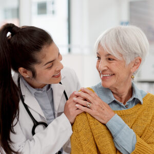 Happy, hug and face of a doctor with a woman for medical trust, healthcare and help. Laughing, care and portrait of a young nurse with a senior patient and love during a consultation at a clinic.